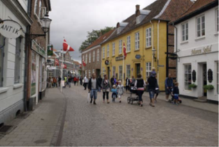 Udstillings- og udeserveringszonen i gågaden er et bånd af slebne chaussésten i hver side af ”kørebanen”.